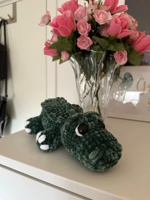 Virkad krokodil  - Super söt handvirkad grön krokodil med urgulliga detaljer! Den är ungefär 30 cm lång. Den har säkerhetsögon som inte rekommenderas för barn under 3 år!🐊