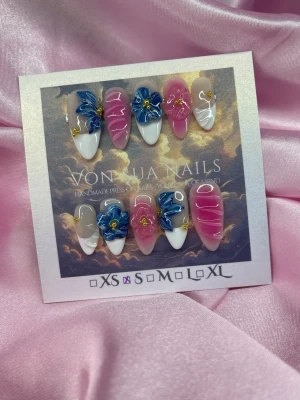 Petals (S);Medium Almond - Unika handgjorda press-on naglar i en medium lång mandelform med rosa, vitt och nude bas, dekorerade med handgjorda 3D-blommor i blått och ljusblått samt 3D nailart-detaljer. Snygg och unik design som sticker ut. Perfekt för dig som vill ha något extra på naglarna.S: 15 mm, 11,5 mm, 12 mm, 11 mm, 9 mm 