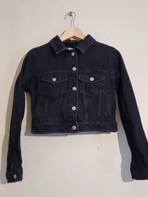 Svart, kort jeansjacka - Svart (washed/distressed finish) kort och figurnära jeansjacka.