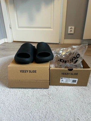 Adidas yeezy slide storlek 43🔥 - Säljer ett par svarta Adidas Yeezy Slide i storlek 43. Riktigt snygga och bekväma slides som passar perfekt till både vardag och avslappnade outfits. Skicket är mycket bra och är använd par gånger, se bilder för detaljer. Pris: 599 kr. Jag är alltid aktiv och svarar snabbt på meddelanden. Fraktar samma dag eller dagen efter beroende på när affären görs. Hör gärna av er via frågor om ni undrar något eller vill ha fler bilder. Först till kvarn!