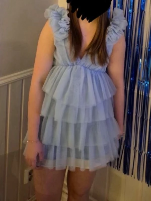 Ljusblå klänninh - Säljer min superfina klänning från Showpo, säljs inte längre på deras hemsida. Endast använd 1 gång och i superfint skick. Storlek 36. Fick inte upp dragkedjan helt så har sytt till snörning längst upp (bild 3), går självklart att ta bort. Har även sytt på ett vitt sidenband längst ner för att göra klänningen lite längre (bild 4)💞bara att höra av sig vid funderingar, är 174 för referens