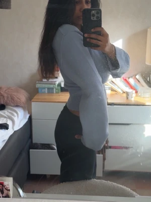 Ljusblå croppad stickad tröja - Trendig ljusblå croppad stickad tröja med breda ärmar och ribbad midja. Perfekt för dig som gillar en avslappnad men ändå snygg stil. Passar till både jeans och kjol för en cool vardagslook.