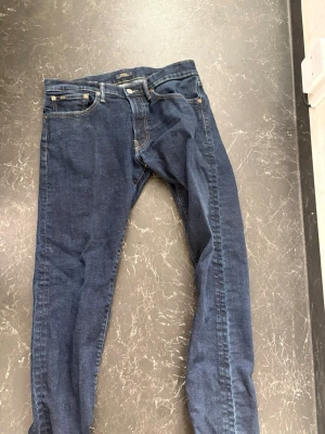Mörkblå raka jeans - Snygga mörkblå jeans med klassisk femficksdesign och raka ben. Jeansen har en enkel look utan slitningar och är tillverkade i denim. Perfekta för en stilren vardagsoutfit.