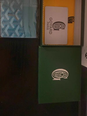 Korthållare - Säljer en blå plånbok  med deras ikoniska grafiska mönster. Plånboken är kompakt och har en stilren design med Paris-logga. Perfekt för dig som gillar exklusiva accessoarer och vill ha något unikt i fickan.