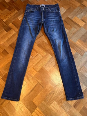 Mörkblå slim fit jeans från velour  - Snygga mörkblå slim fit jeans med klassisk femficksdesign och lätt slitna detaljer framtill. Jeansen har raka ben och normal midja. Perfekta för en trendig och avslappnad look. Skriv vid funderingar 