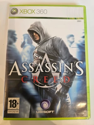 Assassin's Creed till Xbox 360 - Assassin's Creed till Xbox 360, ett actionäventyrsspel där du spelar som lönnmördaren Altaïr under korstågen. Omslaget är grönt och vitt med spelets ikoniska logga och karaktär. Spelboxen är i plast och har PEGI 18-märkning.