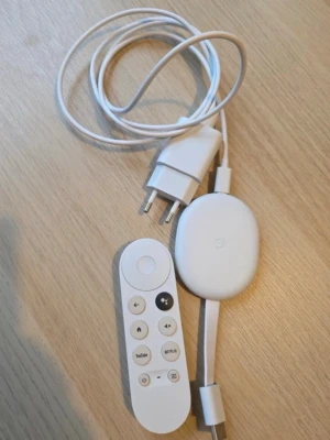 Google Chromecast 4K med fjärrkontroll - Säljer en vit Google Chromecast  4K med fjärrkontroll och strömadapter. Streama enkelt till TV:n via HDMI och styr med fjärren som har dedikerade knappar för YouTube och Netflix. Smidig och modern design i plast, perfekt för att göra din TV smart.