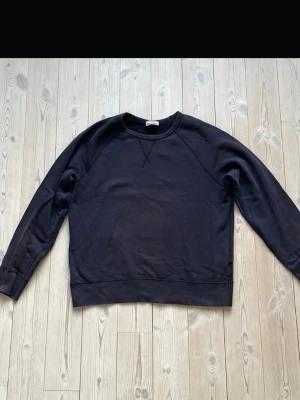 Svart sweatshirt från Acne Studios - Klassisk svart sweatshirt från Acne Studios med rund halsringning och ribbade muddar. Tröjan har en enkel och stilren design med dekorativ söm vid halsen. Perfekt basplagg i mjukt material. Storlek Small och pris kan diskuteras