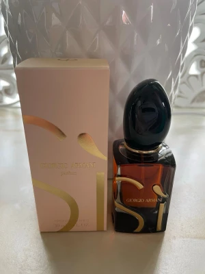 Giorgio Armani Sì Parfum 30ml - Giorgio Armani Sì Parfum i elegant 30 ml flaska. Flaskan är mörk bärnstensfärgad med svart, glansig kork och guldiga detaljer. Kommer i en stilren ljusrosa kartong med gulddetaljer. En lyxig och modern doft som känns exklusiv och trendig.