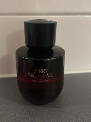 Berry Nightfall parfym från Zara - Berry Nightfall från Zara Night Collection är en parfym i en mörklila, nästan svart, rund glasflaska med svart lock. Flaskan har en stilren och modern design med guldtext på framsidan. Perfekt för dig som gillar bäriga och mystiska dofter. 70ml kvar