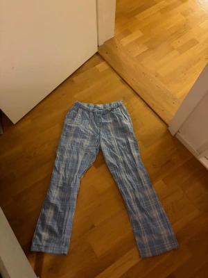 Blå rutiga pyjamasbyxor - Mysiga pyjamasbyxor i blått med vitt rutmönster och resår i midjan. Perfekta för chillkvällar hemma. Lätta och bekväma med avslappnad passform.