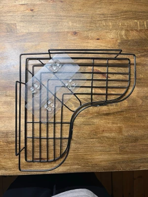 Duschhylla för vägg utan att borra - Praktisk svart hörnhylla i metall och självhäftande fästen i plast. Perfekt för att organisera småsaker i kök, badrum eller andra rum. Hyllan har en modern design med rundade former och öppet galler.