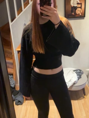 Svart croppad tröja  med vida ärmar - Säljer en svart croppad topp med vida, långa ärmar. Toppen har en tight passform i midjan 