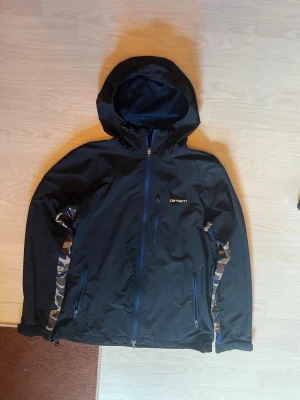 Blue carharrt windbreaker military style - Carhartt windbreaker navy blue. Size medium. Has some removable paint and a small hole on left side of zipper 