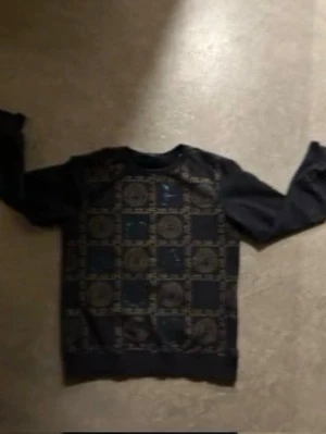 Svart sweatshirt med mönster - Cool svart sweatshirt med unikt geometriskt mönster på framsidan. Tröjan har rund halsringning och långa ärmar, perfekt för en avslappnad streetstyle-look.