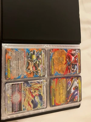 Pokémonkort i samlarpärm - Säljer en samlarpärm fylld med olika Pokémonkort, bland annat flera holografiska och sällsynta kort. Pärmen är svart och korten ligger i plastfickor. Perfekt för dig som vill utöka din samling eller börja samla Pokémonkort.