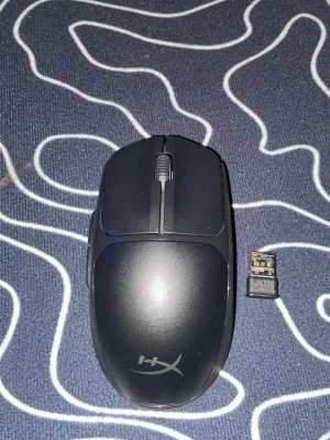 Svart trådlös HyperX gamingmus - Säljer en svart trådlös gamingmus från HyperX med USB-mottagare. Musen har en stilren design med två knappar och scrollhjul. Perfekt för gaming eller vardagsbruk, och enkel att ta med sig tack vare den kompakta formen. Var tyvärr inte kvar lådan den är ungefär 2-3 månader gammal