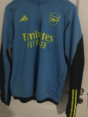 Blå Arsenal träningströja långärmad - Snygg blå långärmad träningströja från Arsenal med Adidas-logga och klubbmärke. Köpte från JD SPORTS för 1200 säljer för 250kr 