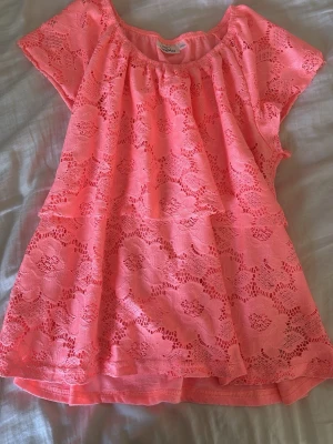 Coral spetsblus från KappAhl - Säljer en söt rosa blus från KappAhl med korta ärmar och rund halsringning. Blusen är täckt av ett blommigt spetsmönster. Perfekt för dig som gillar romantiska detaljer och en feminin look. Pris kan diskuteras och kom gärna med frågor! 💕