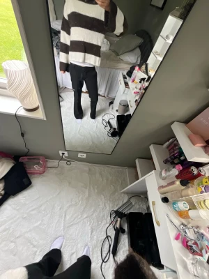 Randig stickad tröja - Mysig stickad tröja med breda bruna och vita ränder. Tröjan har en oversized passform, långa ärmar och mjukt material som ger en avslappnad look. Perfekt för kyliga dagar och enkel att styla med jeans eller byxor.