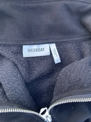 Svart sweatshirt från Weekday - En klassisk svart sweatshirt från Weekday i storlek M. Tröjan har rund halsringning, ribbade muddar vid ärmslut och nederkant samt en mjuk insida i fleece. Perfekt för en avslappnad och stilren look.