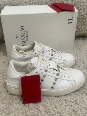 Valentino rockstuds  - Säljer ett par valentino opens rockstuds   i mycket fint skick. Storlek: 37 fits 38 Skick: 9,6/10 Färg: vita med guldiga spikar 📦 Ingår: box + extra snöre + valentino kort💰 Pris: 2499 kr Snabb affär prioriteras – seriösa bud välkomna. Skriv gärna för fler bilder eller frågor.  