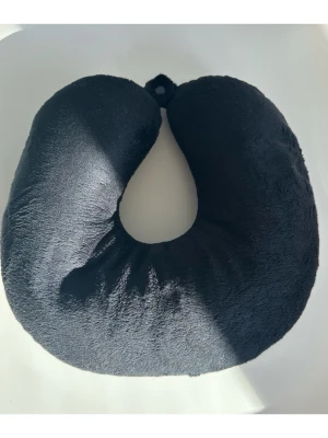 Svart nackkudde / resekudde i mjukt tyg - Stilren svart U-formad nackkudde i mjukt plyschmaterial. Perfekt för resor eller när du vill vila bekvämt. Kudden har en enkel design och är lätt att ta med sig. 30x30cm. Fästes med praktisk tryckknapp. Mycket gott skick, som ny!