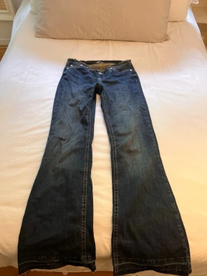 Blå bootcut jeans från Nelly - Säljer ett par blå no waist bootcut jeans från Nelly. Jeansen har utsvängda ben och är tillverkade i denim. I modellen short🥰