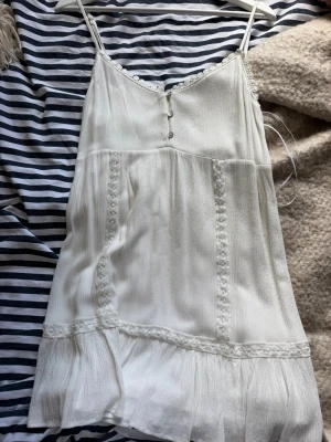 Strandklänning från Pull&Bear - Vit strandklänning från pull&bear. Lite nooorig nertill på högersida, därav priset men funkar perfekt till stranden ändå! Passar S och M.