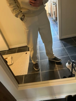 Beiga raka byxor i bomull - Snygga byxor i beige med rak passform och normal midja. Tillverkade i mjukt bomullsmaterial och har en clean, minimalistisk look med sidofickor. Perfekta för dig som gillar enkel och stilren stil. Är 188cm för referens till bilderna. Sitter som 32/34
