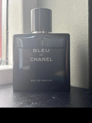 Bleu de Chanel Eau de Parfum 50ml - Bleu de Chanel Eau de Parfum är en elegant herrdoft i en stilren, mörkblå glasflaska med silverdetaljer. Flaskan har en fyrkantig form och kommer med originalförpackning. Doften är maskulin och modern, perfekt för dig som gillar exklusiva parfymer.