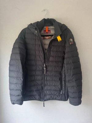 Parajumpers Dunjacka - 🔥 Parajumpers Lightweight Jacka – Svart (Strl M)  Säljer en riktigt clean Parajumpers Lightweight i svart – perfekt för vår, höst eller svala sommarkvällar. Stilren modell som funkar till allt, från vardag till lite mer uppklätt.  ✔️ Storlek: M   ✔️ Skick: Väldigt bra – inga hål eller större slitage   ✔️ Färg: Svart   ✔️ Detaljer: Klassisk PJS patch på armen, flera fickor + ikoniska gula spännet   ✔️ Äkthet: QR-tag finns (kan verifieras)