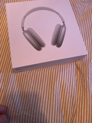 Apple AirPods Max silver hörlurar - Säljer ett par Apple AirPods Max i färgen silver. Over-ear design med mjuka öronkuddar och justerbart huvudband. Tillverkade i aluminium och rostfritt stål med mesh-material på huvudbandet. Grym ljudkvalitet och stilren look, perfekt för musik och poddar.