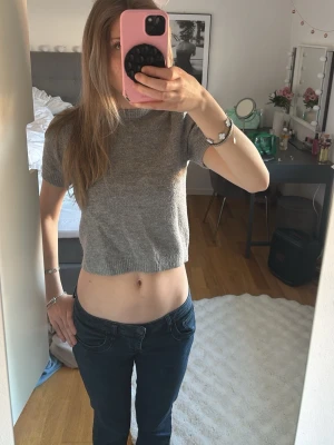 Grå kortärmad stickad tröja - Kortärmad, croppad stickad tröja i mjukt grått material från ZARA. Tröjan har rund halsringning och ribbade kanter vid ärmslut och nederkant. Perfekt till jeans eller kjol för en enkel och stilren look💗