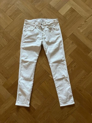 Vita replay jeans  - Säljer ett par vita replay jeans med klassisk femficksdesign och normalhög midja. Jeansen har smal passform hela vägen ner och är tillverkade i stretchigt bomullsmaterial för extra komfort. Perfekta till en clean och fräsch look.