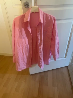 Ljusrosa skjorta med knappar - Säljer en ljusrosa skjorta i storlek S. Skjortan har klassisk krage, långärmad design och knappar framtill. Perfekt för dig som gillar färg och vill ha något enkelt men snyggt. Materialet känns som bomull och skjortan har en normal passform.