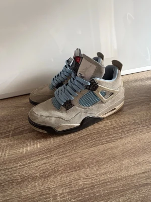 Air Jordan 4 Retro Univeristy blue. - Säljer ett par Air Jordan 4 Retro Union Guava Ice sneakers med beige mocka, ljusblå mesh och detaljer samt svarta och röda accenter. Skorna har högt skaft och klassisk Jumpman-logga på hälen. Perfekta för dig som gillar streetwear och unika sneakers. Storlek 42 men passar 43. 7/10 skick, inga hål men smutsiga. Priset kan diskuteras!