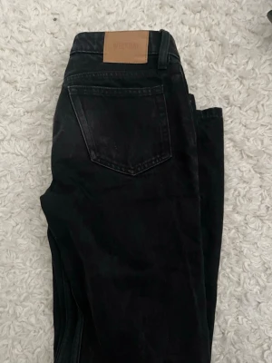 Svarta raka jeans från Weekday - Säljer ett par svarta jeans från Weekday med raka ben och klassisk femficksmodell. Jeansen har gylf med dragkedja och knapp, samt en snygg tvättad finish. Perfekta till vardagslooken och passar till det mesta.