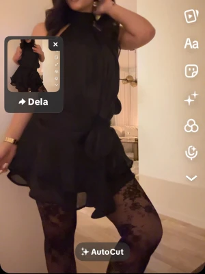 Svart volangklänning med knyt - Säljer en svart kortklänning med volangdetaljer och knyt i midjan. Klänningen har ärmlös design och en flowy passform som ger en snygg siluett. Perfekt för dig som gillar en chic och trendig look.