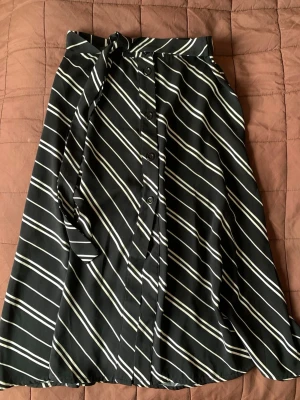 Kjol -BikBok - Randig midikjol från Bik Bok. Knappar framtill och knyte i midjan. Storlek XS. Längd ca 67cm. I fint skick 🌸