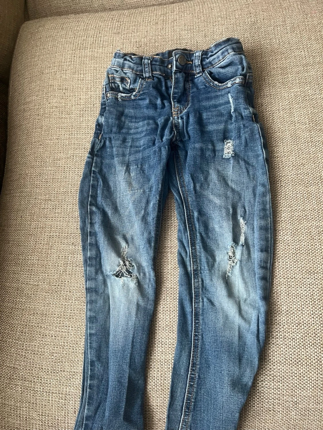 Blå slitna jeans