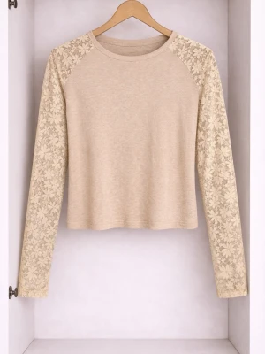 Beige topp med spetsärmar - Beige långärmad topp med transparenta spetsärmar i blommigt mönster. Rund halsringning och rak passform. Perfekt att styla med jeans eller kjol för en trendig look.