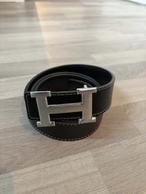 Svart Herme$ bälte  - Svart bälte med silver H logga i 110cm