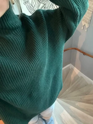 Mörkgrön ribbstickad tröja - Säljer en mörkgrön ribbstickad tröja med hög krage och långa ärmar. Lite för stor för mig men annars jättemysig och bekväm!! skriv privat om ni vill ha fler bilder, eller ifall det skulle vara något annat!! 