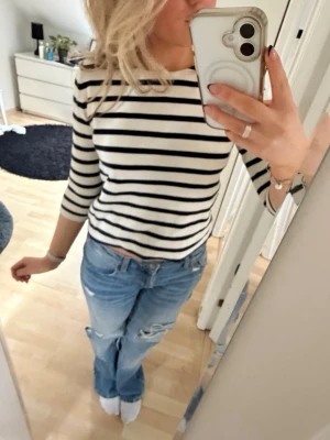 Vit och svartrandig topp💕 - Säljer en vit och svart randig topp med trekvartsärm och rak passform. Toppen har båtringad hals och är medelcroppad. Jättesnygg och passar till allt. Lite tjockare material. Älskar verkligen denna men har tyvärr inte plats för den längre. Perfekt året runt💕 Den är i väldigt fint skick trots att den är använt typ 5 gånger. Passar alla storlekar upp till M skulle jag säga då den är i XS men jag som har M kan ha på sig den💕 Hör av er om frågor uppkommer🫶