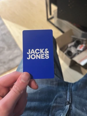 Jack & Jones presentkort blå - Presentkort från Jack & Jones i blå färg med vit logga på framsidan. Kortet är i plast och har standard kreditkortsformat. Perfekt för att handla kläder och accessoarer från Jack & Jones.  1000kr på det. Säljes för 900kr 
