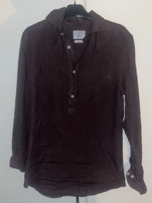 Mörkbrun linneskjorta  - En härlig sommar skjorta med linne material. Storleken på denna skjorta är S. Helt ny använd 1 gång. Pris kan diskuteras