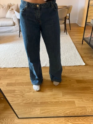 Blå raka jeans från NA-KD - Säljer ett par klassiska blå jeans från NA-KD i rak modell. Jeansen är uppsydda och har visst slitage längst ner.