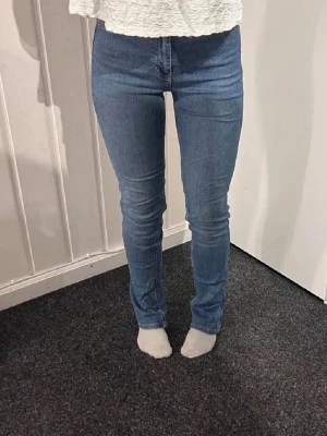Jeans - blå jeans med hög midja, Jeansen har en smal passform till längre ner där de är lite vida