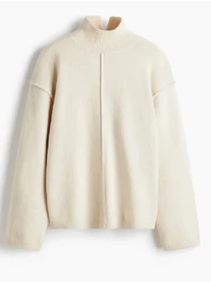 Beige stickad tröja med hög krage - En stilren beige stickad tröja med hög krage och rak passform. Tröjan har en söm framtill och ribbade muddar vid hals, ärmslut och nederkant. Perfekt för lager-på-lager och enkel att matcha med olika outfits. Den är helt oanvänd och jag säljer då den tyvärr var för liten för mig💞 